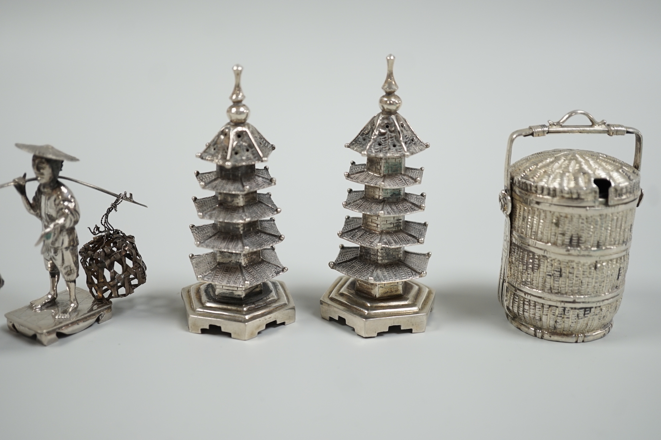 A Chinese white metal 'wedding basket' by Wang Hing, 63mm, a pair of similar white metal pagoda condiments, KSM and a figure.